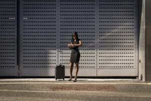 Businesswoman with trolley checking the time